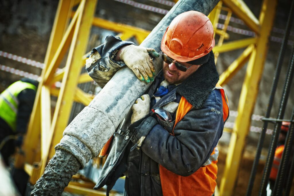 pexels-photo-585419-585419 Construction worker in safety gear handling equipment on an active site.